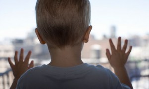 Close up of boy (21-24 months) looking out window, rear view